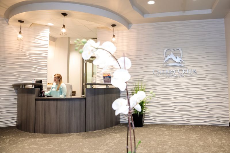 Warmly lit reception area inside Cherry Creek Dental Spa